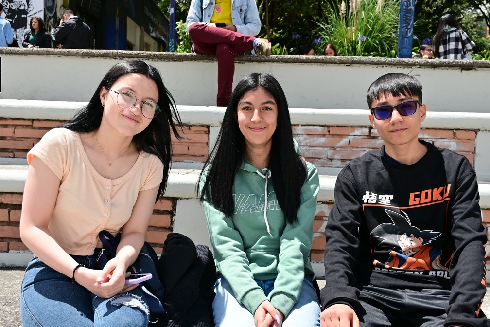 Tres estudiantes sentados en las gradas del bloque C